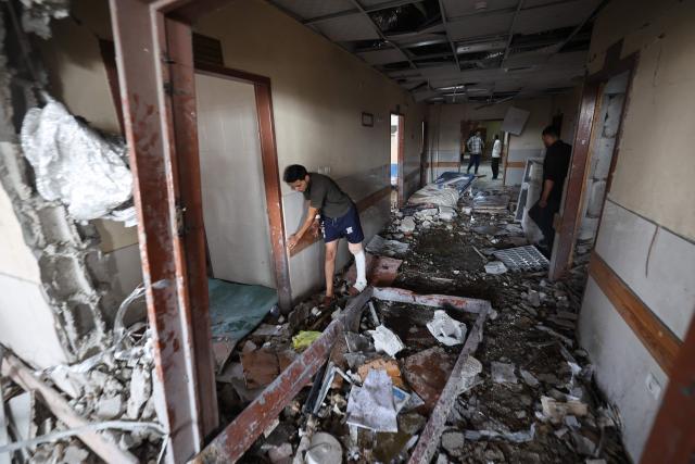 EDITORS NOTE: Graphic content / TOPSHOT - Palestinians inspect the destruction inside Nasser hospital in Khan Yunis in the southern Gaza Strip, following an Israeli strike early on May 13, 2025 in which Palestinian journalist Hassan Aslih was killed along with several others. The Israeli military said it struck a Gaza hospital "housing Hamas militants" in a raid on May 13 which, according to the Palestinian group, killed the journalist who had been wounded in an Israeli attack last month and a number of civilians. (Photo by Eyad BABA / AFP)
