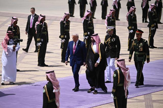 Saudi Crown Prince Mohammed bin Salman (C-R) walks with US President Donald Trump upon his arrival in Riyadh on May 13, 2025. (Photo by Brendan SMIALOWSKI / AFP)