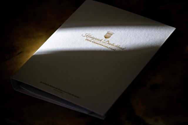 (FILES) A file with the emblem of the so-called 'Kingdom of Germany' (Koenigreich Deutschland), is pictured in Wittenberg, eastern Germany on October 23, 2023. German authorities on May 13, 2025 launched multiple raids against an extremist network and dissolved the so-called "Kingdom of Germany", the interior ministry said. The Federal Prosecutor's Office also announced the arrest of four people during the raids, including three founding members of the group. Described as "dangerous extremists" by the ministry, the Kingdom of Germany is part of the German conspiracy movement known as the "Citizens of the Reich", which rejects the legitimacy of the modern German republic. (Photo by JENS SCHLUETER / AFP)