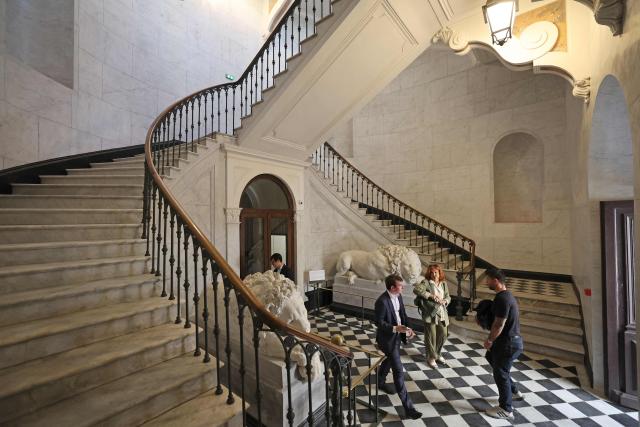 People stand  in the entrance hall of the renovated Fesch municipal library during its re-opening inauguration in Ajaccio on the French Mediterranean island of Corsica, on May 13, 2025. (Photo by Pascal POCHARD-CASABIANCA / AFP)