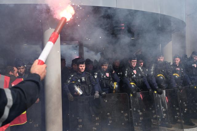 Riot police forces stand guard as ArcelorMittal employees hold a rally outside the group's headquarters to put pressure on the French management of the steelmaker, which is planning to cut more than 600 jobs in Saint-Denis near Paris, on May 13, 2025. (Photo by LEO VIGNAL / AFP)