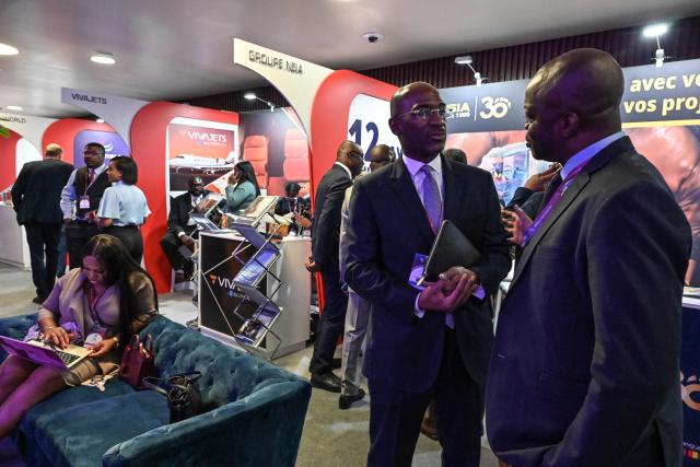 Attendees talk between sessions on the second day of the Africa CEO Forum annual summit in Abidjan on May 13, 2025. (Photo by Issouf SANOGO / AFP)