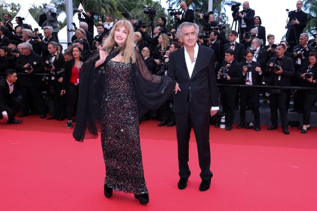 US-born French actress, singer, director and model Arielle Dombasle (L) and her husband French philosopher Bernard-Henri Levy arrive for the Opening Ceremony and the screening of the film "Partir un Jour" (Bye Bye) presented out of competition at the 78th edition of the Cannes Film Festival in Cannes, southern France, on May 13, 2025. (Photo by Sameer Al-Doumy / AFP)