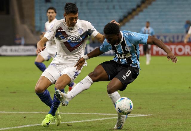 Godoy Cruz's forward #41 Facundo Altamira (L) and Gremio's Belgian midfielder #09 Francis Amuzu fight for the ball during the Copa Sudamericana group stage football match between Brazil's Gremio and Argentina's Godoy Cruz, at the Arena do Gremio stadium in Porto Alegre, state of Rio Grande do Sul, Brazil, on May 13, 2025. (Photo by SILVIO AVILA / AFP)