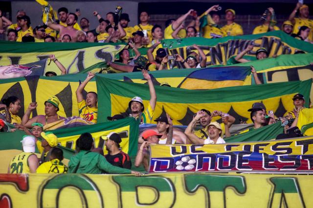 Fans of Bucaramanga cheer for their team ahead of the Copa Libertadores group stage football match between Brazil's Fortaleza and Colombia's Atletico Bucaramanga, at the Arena Castelao stadium in Fortaleza, state of Ceara, Brazil, on May 13, 2025. (Photo by Thiago GADELHA / AFP)