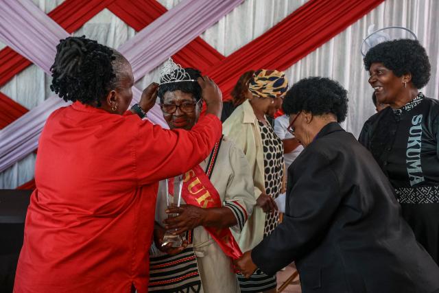 Margaret Fatyela, 78, (2nf L) reacts while being crowned the Sukuma Mbokodo Support Group’s Elderly Beauty Contest winner in Thokoza on May 13, 2025. (Photo by Phill Magakoe / AFP)