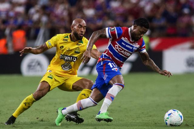 Bucaramanga's midfielder #08 Fredy Hinestroza (L) and Fortaleza's forward #11 Marinho fight for the ball during the Copa Libertadores group stage football match between Brazil's Fortaleza and Colombia's Atletico Bucaramanga, at the Arena Castelao stadium in Fortaleza, state of Ceara, Brazil, on May 13, 2025. (Photo by Thiago GADELHA / AFP)