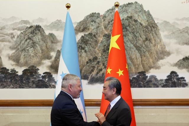 Chinese Foreign Minister Wang Yi and Honduras Foreign Minister Eduardo Enrique Reina shake hands before their meeting at the Diaoyutai State Guesthouse in Beijing on May 14, 2025. (Photo by FLORENCE LO / POOL / AFP)