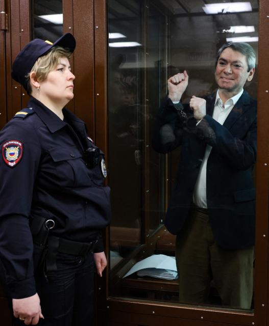Grigory Melkonyants, the co-chair of independent Russian election monitoring group Golos, accused of cooperation with an "undesirable" organisation, reacts inside the glass defendants' box during the verdict announcement at the Basmanny district court in Moscow on May 14, 2025. (Photo by STRINGER / AFP)