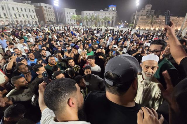 Libyan protesters take to the streets through Tripoli's Martyrs Square to call for the resignation of the national unity government late on May 14, 2025, following renewed clashes in Libya's capital. Fresh gunbattles erupted on May 14 in Tripoli between two powerful armed groups, a day after authorities declared the fighting over. Local state television and residents said the battles eased towards the end of the day. (Photo by AFP)
