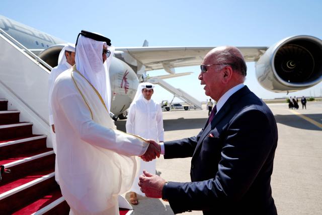 Iraq's Foreign Minister Fuad Hussein (R) welcomes Qatar's Emir Sheikh Tamim bin Hamad al-Thani as he arrives in Baghdad ahead of the 34th Arab League summit on May 17, 2025. (Photo by Murtadha AL-SUDANI / POOL / AFP)