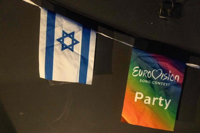 An Israeli flag hangs next to a Eurovision flag during a screening of the 2025 Eurovision Song Contest finals at a community center in Tel Aviv, Israel, on May 17, 2025. Austria's JJ won the 2025 Eurovision Song Contest on May 18, with his operatic song "Wasted Love" triumphing at the world's biggest live music television event. After the nail-biting drama as the votes were revealed running into Sunday morning, Austria finished with 436 points, ahead of Israel on 357 and Estonia on 356. (Photo by Maya Levin / AFP)