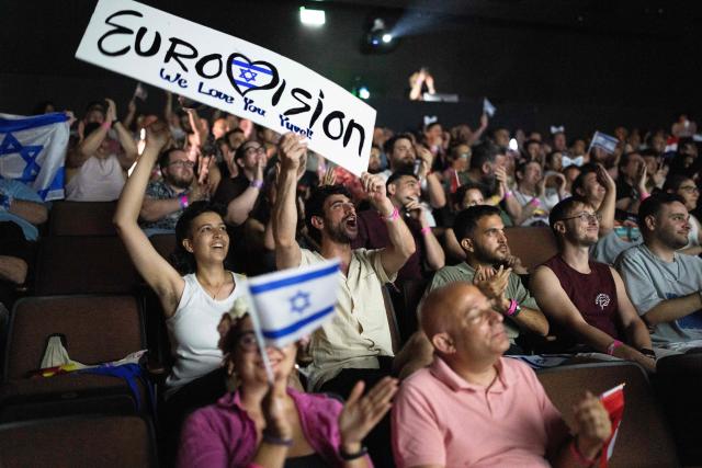 People cheer as they watch the 2025 Eurovision Song Contest finals being screened at a community center in Tel Aviv, Israel, on May 17, 2025. Austria's JJ won the 2025 Eurovision Song Contest on May 18, with his operatic song "Wasted Love" triumphing at the world's biggest live music television event. After the nail-biting drama as the votes were revealed running into Sunday morning, Austria finished with 436 points, ahead of Israel on 357 and Estonia on 356. (Photo by Maya Levin / AFP)