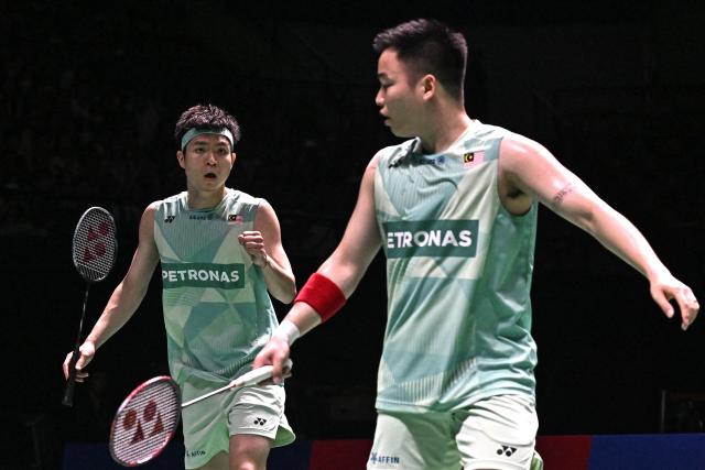 Malaysia’s Soh Wooi Yik (L) and teammate Aaron Chia (R) celebrate winning a point against Denmark’s William Kryger Boe and Christian Faust Kjaer during the men’s doubles final at the 2025 Thailand Open badminton tournament in Bangkok on May 18, 2025. (Photo by Lillian SUWANRUMPHA / AFP)