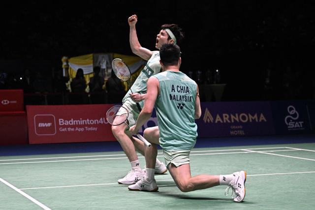Malaysia’s Soh Wooi Yik (back) and Aaron Chia (front) celebrate after winning against Denmark’s William Kryger Boe and Christian Faust Kjaer during the men’s doubles final at the 2025 Thailand Open badminton tournament in Bangkok on May 18, 2025. (Photo by Lillian SUWANRUMPHA / AFP)