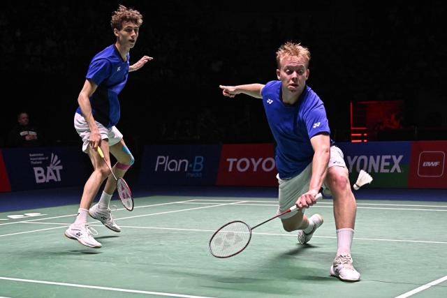 Denmark’s Christian Faust Kjaer (R) hits a return as teammate William Kryger Boe (L) looks on during the men’s doubles final against Malaysia’s Soh Wooi Yik and Aaron Chia at the 2025 Thailand Open badminton tournament in Bangkok on May 18, 2025. (Photo by Lillian SUWANRUMPHA / AFP)