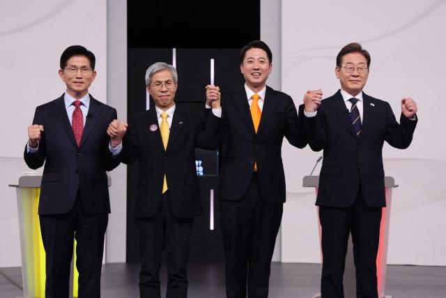 (L to R) South Korea's presidential candidates, Kim Moon Soo of the People Power Party, Kwon Young-guk of the Democratic Labor Party, Lee Jun-seok of the New Reform Party and Lee Jae-myung of the Democratic Party pose for photographs ahead of a televised presidential debate for the forthcoming June 3 presidential election at SBS studio in Seoul on May 18, 2025. (Photo by Chung Sung-Jun / POOL / AFP)