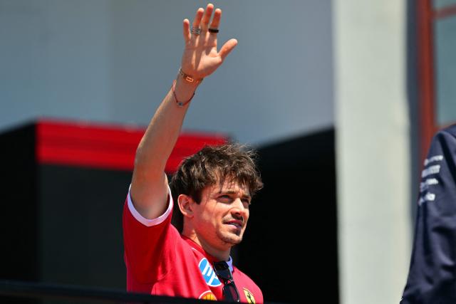 Ferrari's Monegasque driver Charles Leclerc gestures to supporters as he arrives for the 2025 Emilia Romagna Formula One Grand Prix at the Imola autodrome in Imola, on May 18, 2025. (Photo by Andrej ISAKOVIC / AFP)