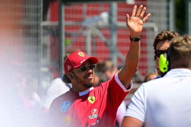 Ferrari's British driver Lewis Hamilton waves as he arrives for the 2025 Emilia Romagna Formula One Grand Prix at the Imola autodrome in Imola, on May 18, 2025. (Photo by Andrej ISAKOVIC / AFP)