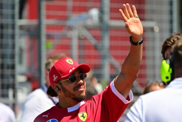 Ferrari's British driver Lewis Hamilton waves as he arrives for the 2025 Emilia Romagna Formula One Grand Prix at the Imola autodrome in Imola, on May 18, 2025. (Photo by Andrej ISAKOVIC / AFP)