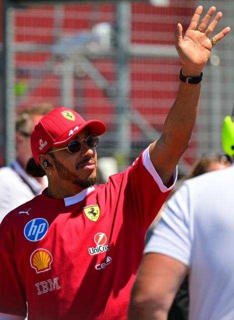 Ferrari's British driver Lewis Hamilton waves as he arrives for the 2025 Emilia Romagna Formula One Grand Prix at the Imola autodrome in Imola, on May 18, 2025. (Photo by Andrej ISAKOVIC / AFP)
