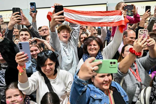 Fans of Austrian singer Johannes Pietsch aka JJ, winner of the 2025 Eurovision Song Contest, cheer as he arrives at Vienna International Airport in Schwechat, Austria on May 18, 2025. Austria's JJ won the 2025 Eurovision Song Contest on May 17 in Basel, with his operatic song "Wasted Love" triumphing at the world's biggest live music television event. (Photo by Joe Klamar / AFP)