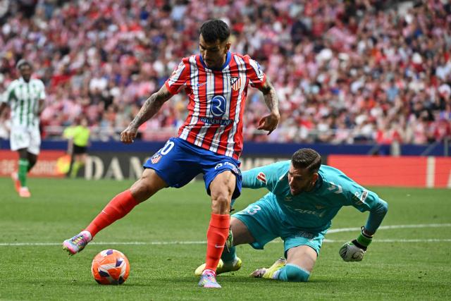 Atletico Madrid's Argentine forward #10 Angel Correa and Real Betis' Spanish goalkeeper #13 Adrian fight for the ball during the Spanish league football match between Club Atletico de Madrid and Real Betis at Metropolitano Stadium in Madrid on May 18, 2025. (Photo by JAVIER SORIANO / AFP)