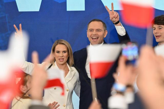 Karol Nawrocki (R), Presidential candidate for the 2025 Polish presidential election supported by Poland's right-wing Law and Justice (PiS) party, greets supporters with his wife as first exit polls following Presidential elections are announced in Gdansk, on May 18, 2025. (Photo by Mateusz SLODKOWSKI / AFP)