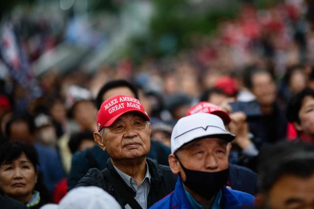 Supporters of South Korean presidential candidate, Kim Moon Soo of the People Power Party listen to him speaking during a campaign event for the forthcoming June 3 presidential election in Seoul on May 19, 2025. (Photo by ANTHONY WALLACE / AFP)