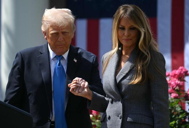 US President Donald Trump holds hands with US First Lady Melania Trump before signing the "Take It Down Act" during a bill signing ceremony in the Rose Garden of the White House in Washington, DC, on May 19, 2025. The bipartisan legislation will criminalize the non-consenual publication of  sexual imagery, including AI-generated deepfakes and "revenge porn." (Photo by Jim WATSON / AFP)
