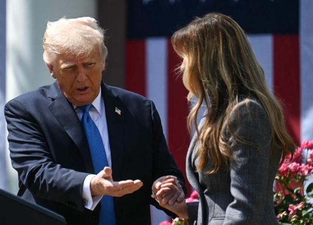 US President Donald Trump holds hands with US First Lady Melania Trump before signing the "Take It Down Act" during a bill signing ceremony in the Rose Garden of the White House in Washington, DC, on May 19, 2025. The bipartisan legislation will criminalize the non-consenual publication of  sexual imagery, including AI-generated deepfakes and "revenge porn." (Photo by Jim WATSON / AFP)