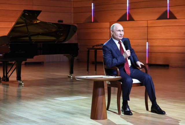 In this pool photograph distributed by the Russian state agency Sputnik, Russian President Vladimir Putin talks with students at the Sirius Educational Center in Sochi on May 19, 2025, after a telephone conversation with US President Donald Trump. (Photo by Alexander KAZAKOV / POOL / AFP)