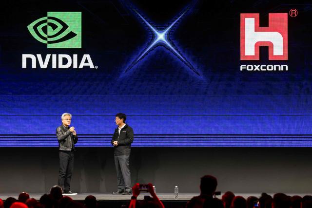 Nvidia co-founder and CEO Jensen Huang (L) shows up as a guest during Foxconn Chairman Young Liu's keynote speech for Computex 2025 at the Taipei Nangang Exhibition Center Hall in Taipei on May 20, 2025. (Photo by I-Hwa Cheng / AFP)