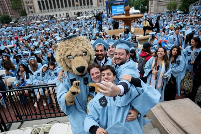 Students pose with a person dressed as Roar-ee the Lion mascot, before the Commencement Ceremony at Columbia University in New York on May 21, 2025, (Photo by Jeenah Moon / POOL / AFP)