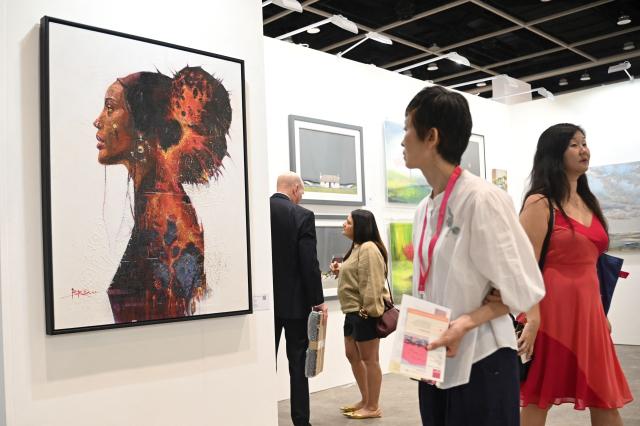 Visitors look at artworks by various artists at the Affordable Art Fair in Hong Kong on May 22, 2025. (Photo by Peter PARKS / AFP)