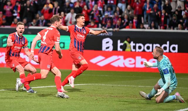 Heidenheim's German defender #04 Tim Siersleben (2L) celebrates with teammates scoring during the German Bundesliga relegation first-leg football match  between FC Heidenheim and SV Elversberg in Heidenheim on May 22, 2025. (Photo by THOMAS KIENZLE / AFP) / DFL REGULATIONS PROHIBIT ANY USE OF PHOTOGRAPHS AS IMAGE SEQUENCES AND/OR QUASI-VIDEO