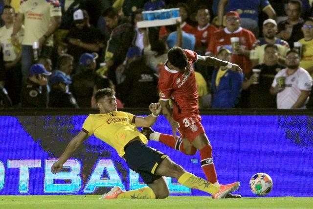America's Uruguayan defender #04 Sebastian Caceres and Toluca's Paraguayan forward #31 Robert Morales fight for the ball during the Liga MX Clausura tournament final first leg football match between America and Toluca at Ciudad de los Deportes stadium in Mexico City on May 22, 2025. (Photo by Victor Cruz / AFP)