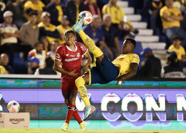 America's Colombian defender #26 Cristian Borja clears the ball in front of Toluca's defender #03 Antonio Briseno during the Liga MX Clausura tournament final first leg football match between America and Toluca at Ciudad de los Deportes stadium in Mexico City on May 22, 2025. (Photo by Rodrigo Oropeza / AFP)