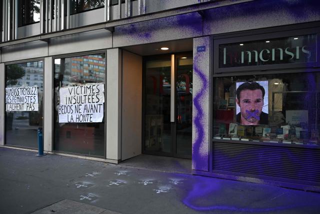 A picture of Nicolas Bedos with a cross over the mouth is seen on the facade of the publishing house Humensis following an action by activists from the feminist collective "NousToutes"  to protest against the publication of  Nicolas Bedos' latest book “La soif de honte” in Paris, on May 23, 2025. French actor-writer-director Nicolas Bedos was sentenced at first instance on October 2024 to one year in prison with six months suspended for sexually assaulting two women. (Photo by Leo VIGNAL / AFP)
