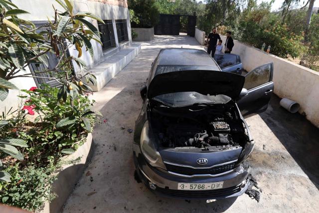 Palestinian resident of Bruqin in the occupied-West Bank, stand next to a car reportedly set on fire during an overnight attack by Israeli settlers, on May 23, 2025. The West Bank is home to about three million Palestinians, but also some 500,000 Israelis living in settlements that are considered illegal under international law. (Photo by JAAFAR ASHTIYEH / AFP)