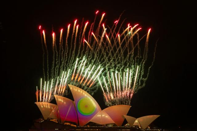 Fireworks explode as the sails of the Sydney Opera House are illuminated with lights at the start of the annual Vivid Sydney festival in Sydney on May 23, 2025. (Photo by Ayush Kumar / AFP)