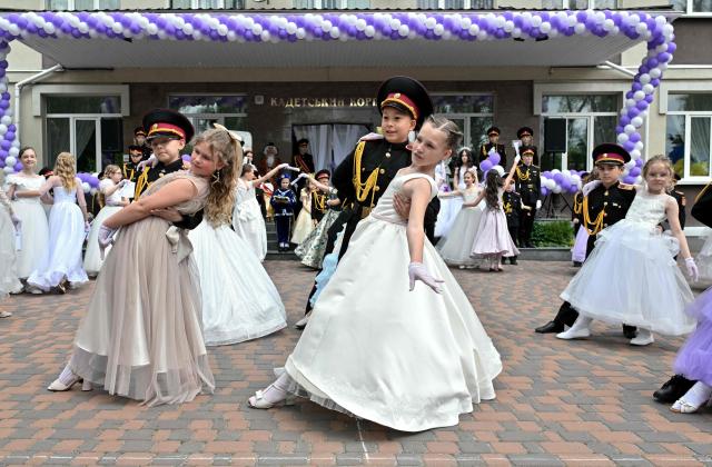 Young Ukrainian cadets of the "Cadet Corps" of the military boarding school in Kyiv dance with young girls during the end of school year graduation ball on May 23, 2025, amid Russian invasion in Ukraine. Some of cadets are children of servicemen fallen during the war with Russia. (Photo by Sergei SUPINSKY / AFP)