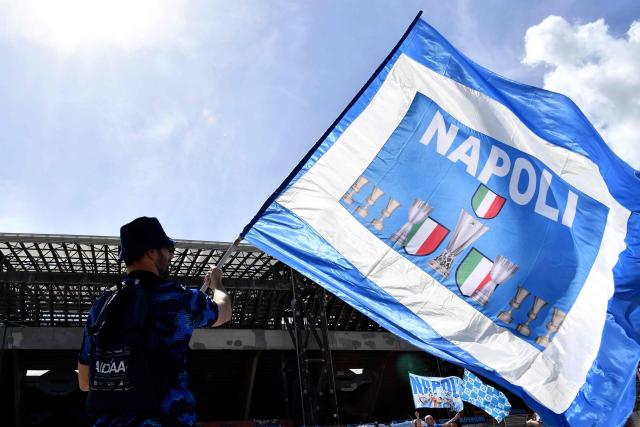 A supporter of Napoli waves a flag before the Italian Serie A football match between Napoli and Cagliari at the Diego Armando Maradona stadium in Naples on May 23, 2025. (Photo by Isabella BONOTTO / AFP)
