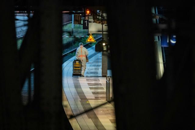 A Forensic Police officer is seen on the railway platform at Hamburg's main train station where at least 12 people have been injured in a knife attack on May 23, 2025. A knife attack at the main station in the German city of Hamburg left at least 12 people injured with some of them in a life-threatening condition, local emergency services said. (Photo by Jonas Walzberg / AFP)