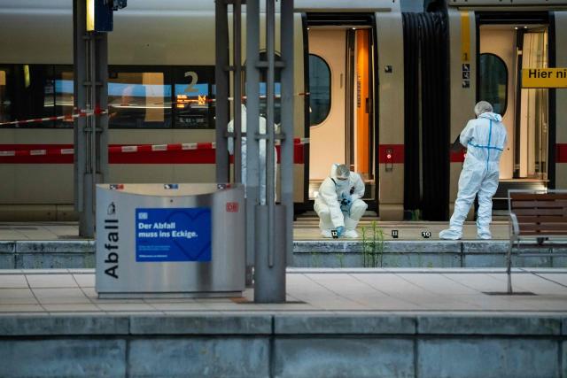 Forensic police officers investigate on the railway platform at Hamburg's main train station where at least 12 people have been injured in a knife attack on May 23, 2025. A knife attack at the main station in the German city of Hamburg left at least 12 people injured with some of them in a life-threatening condition, local emergency services said. (Photo by Jonas Walzberg / AFP)