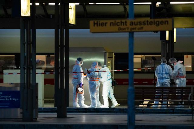 Forensic police officers investigate on the railway platform at Hamburg's main train station where at least 12 people have been injured in a knife attack on May 23, 2025. A knife attack at the main station in the German city of Hamburg left at least 12 people injured with some of them in a life-threatening condition, local emergency services said. (Photo by Jonas Walzberg / AFP)