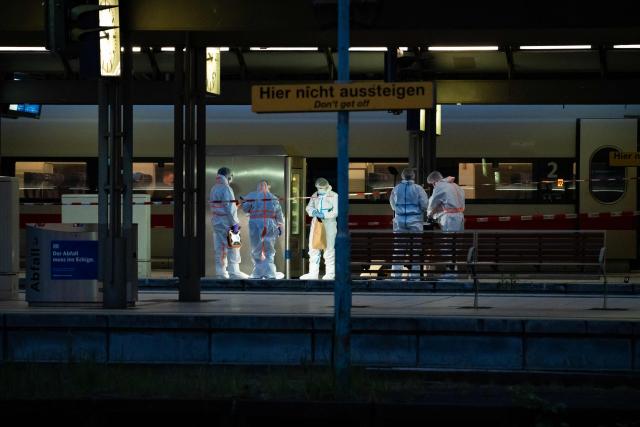 Forensic police officers investigate on the railway platform at Hamburg's main train station where at least 12 people have been injured in a knife attack on May 23, 2025. A knife attack at the main station in the German city of Hamburg left at least 12 people injured with some of them in a life-threatening condition, local emergency services said. (Photo by Jonas Walzberg / AFP)