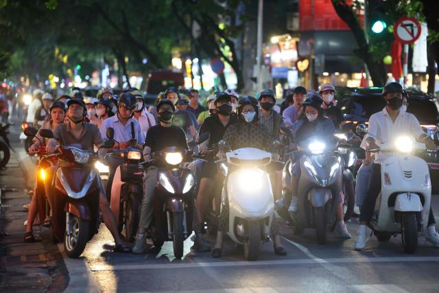 Motorbikes wait at a trafic light in Hanoi on may 23, 2025. (Photo by Ludovic MARIN / AFP)