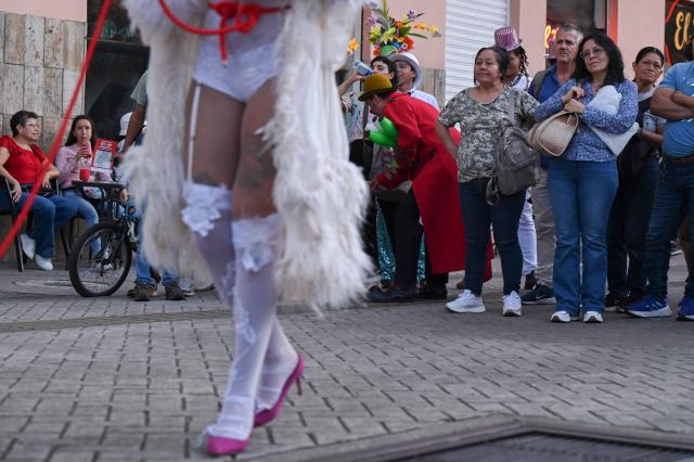 People watch an artist perform during the inauguration of Cali’s International Theater Festival in Cali, Valle del Cauca department, Colombia on May 23, 2025. The festival will take place until the 30th of May. (Photo by JOAQUIN SARMIENTO / AFP)