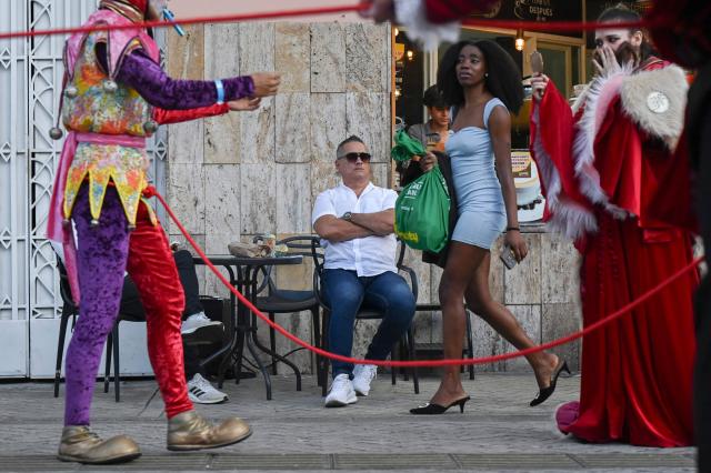 A man watches artists perform during the inauguration of Cali’s International Theater Festival in Cali, Valle del Cauca department, Colombia on May 23, 2025. The festival will take place until the 30th of May. (Photo by JOAQUIN SARMIENTO / AFP)